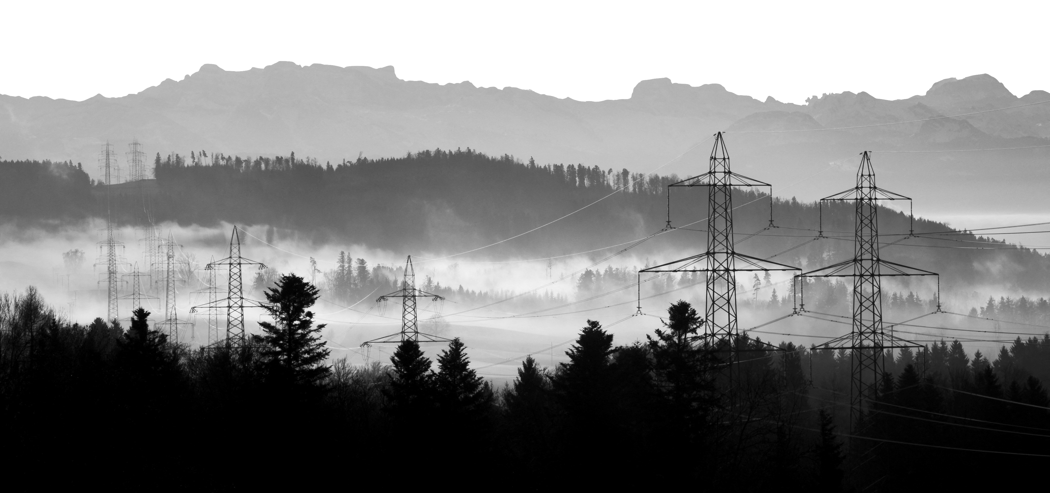 Power lines over misty mountains